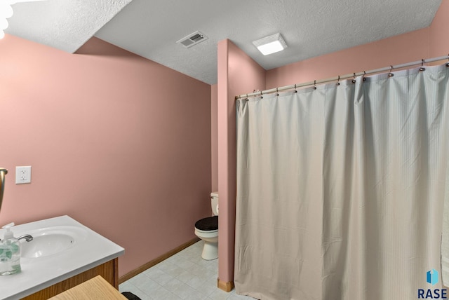 bathroom with a textured ceiling, toilet, baseboards, visible vents, and vanity