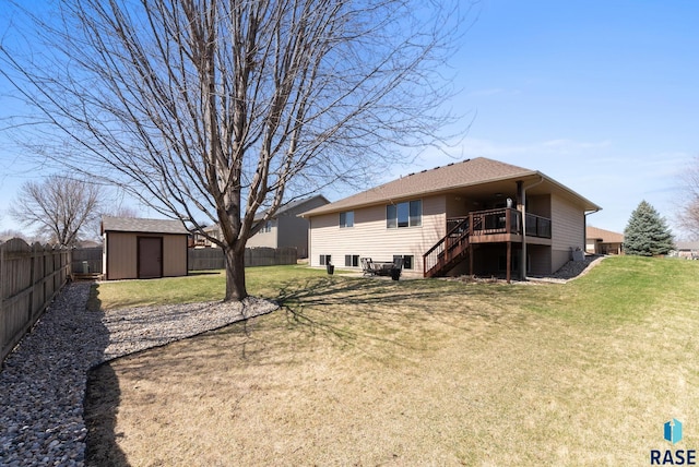 rear view of house featuring stairs, a yard, a shed, an outbuilding, and a fenced backyard
