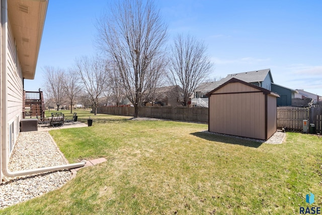 view of yard featuring an outbuilding, a patio area, a fenced backyard, and a shed
