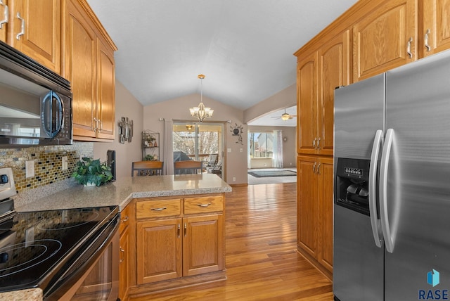 kitchen with an inviting chandelier, black microwave, stainless steel refrigerator with ice dispenser, light wood-style floors, and electric range