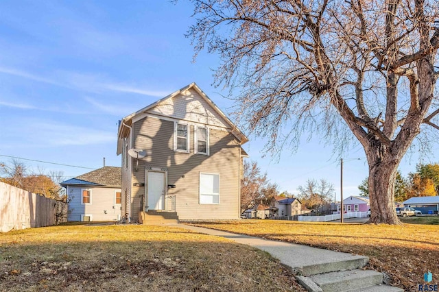 view of front of house with a front yard and fence