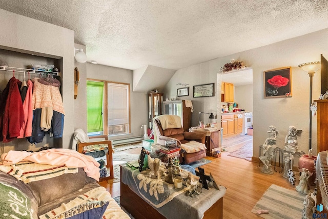 living area with baseboard heating, light wood-style flooring, and a textured ceiling