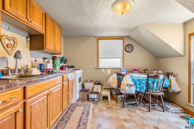 kitchen with a sink, brown cabinets, a textured ceiling, stone finish flooring, and white range with gas stovetop