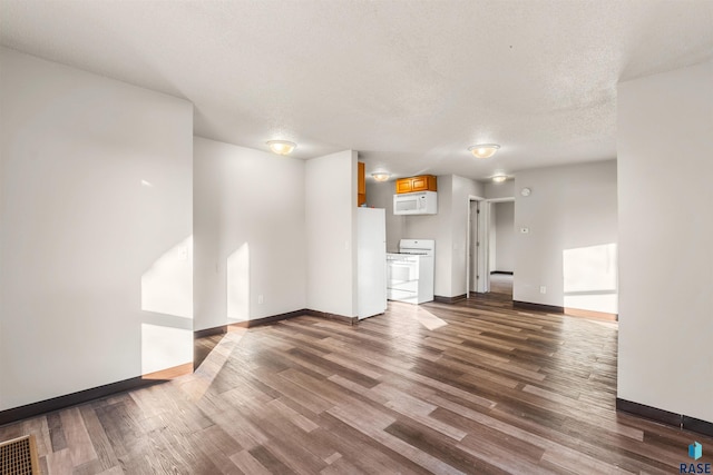 unfurnished living room featuring dark wood finished floors, visible vents, baseboards, and a textured ceiling