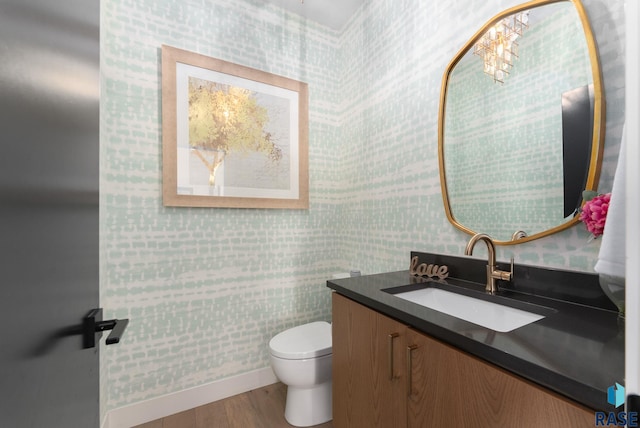 112 N Harvest Hill Cir, Sioux Falls, SD 57110 - half bath featuring toilet, wood finished floors, vanity, baseboards, and wallpapered walls