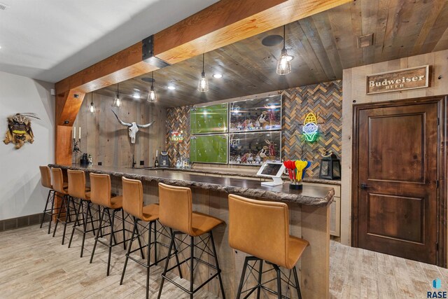 5604 S Jersey Tess Dr, Sioux Falls, SD 57108 - bar with hanging light fixtures, wet bar, wood finished floors, and baseboards