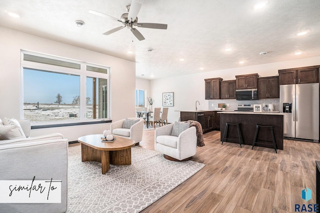 6218 S Tanner Ave, Sioux Falls, SD 57108 - living room with light wood finished floors, ceiling fan, and recessed lighting