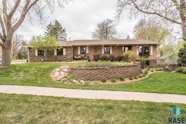 ranch-style home featuring fence and a front yard