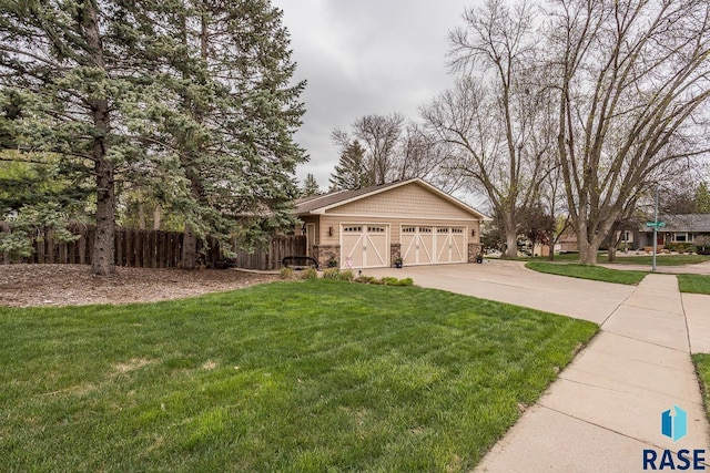 exterior space with fence, driveway, stone siding, and a lawn