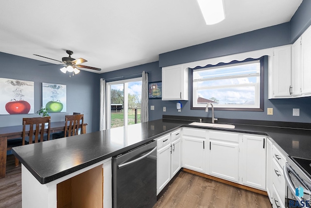 46902 284th St, Lennox, SD 57039 - kitchen with a sink, white cabinetry, a peninsula, dark countertops, and stainless steel appliances