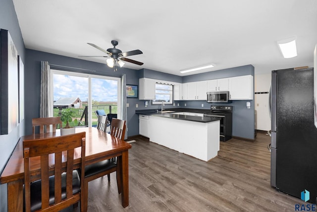 46902 284th St, Lennox, SD 57039 - kitchen featuring dark wood-style flooring, ceiling fan, white cabinetry, dark countertops, and appliances with stainless steel finishes