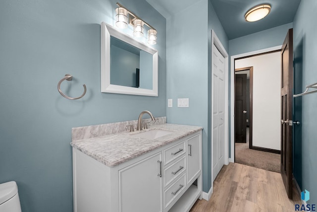 46902 284th St, Lennox, SD 57039 - bathroom featuring vanity, toilet, baseboards, and wood finished floors