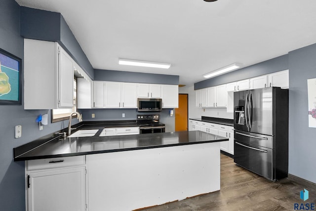 46902 284th St, Lennox, SD 57039 - kitchen featuring a sink, a peninsula, dark countertops, and appliances with stainless steel finishes