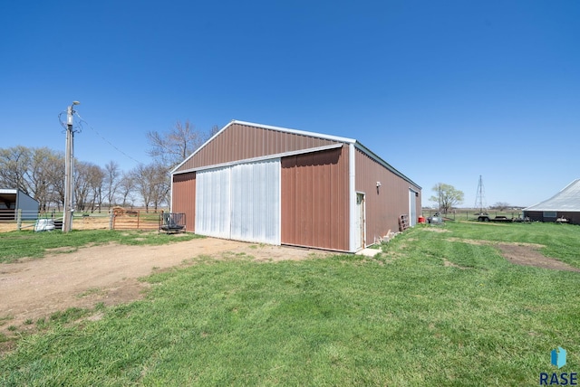 46902 284th St, Lennox, SD 57039 - view of pole building featuring driveway, fence, and a lawn