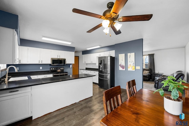 46902 284th St, Lennox, SD 57039 - kitchen with a sink, a peninsula, ceiling fan, dark countertops, and appliances with stainless steel finishes
