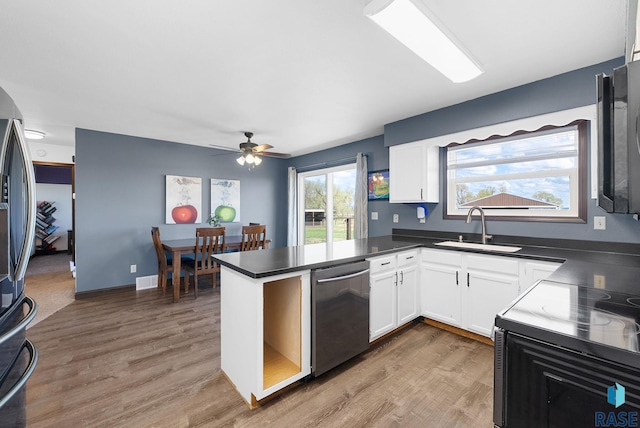 46902 284th St, Lennox, SD 57039 - kitchen with a peninsula, a sink, dark countertops, white cabinetry, and appliances with stainless steel finishes
