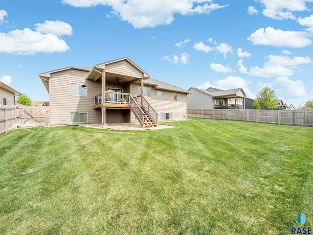back of property with stairway, a ceiling fan, a wooden deck, and a gate