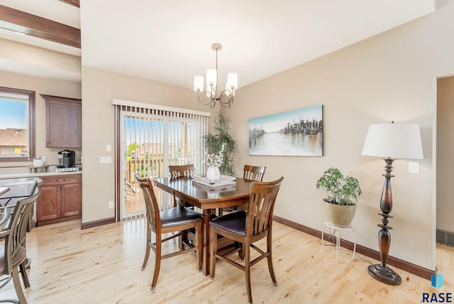 dining space featuring light wood-type flooring, a chandelier, and baseboards