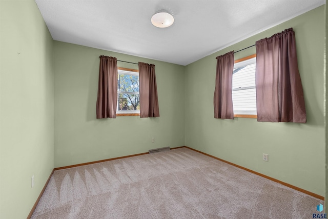 spare room featuring carpet, baseboards, and visible vents