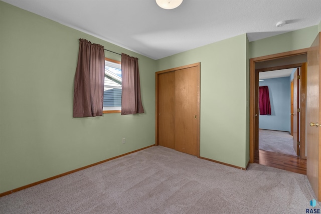 unfurnished bedroom with a closet, baseboards, and carpet floors