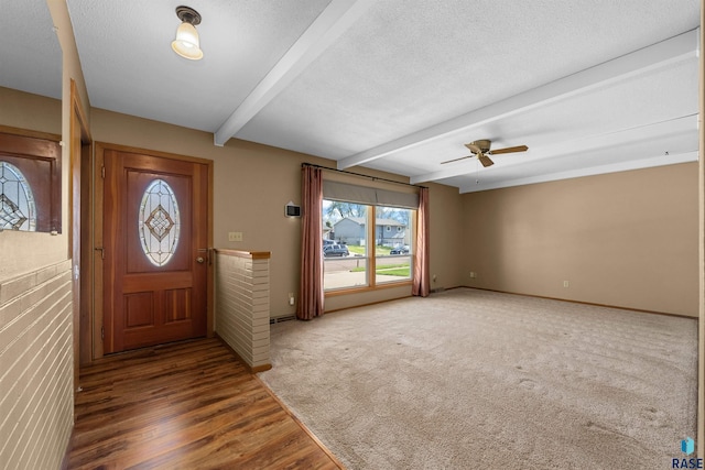 entrance foyer featuring beamed ceiling, a ceiling fan, baseboards, and wood finished floors