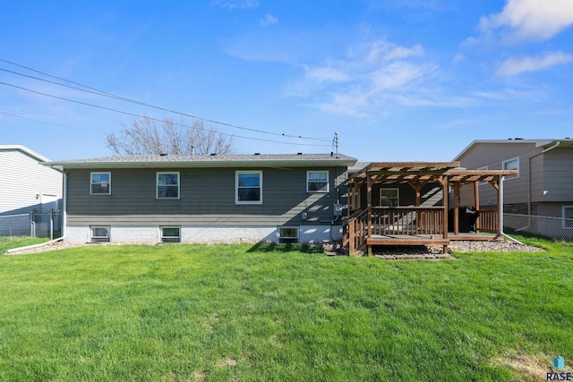 rear view of house featuring a lawn, a wooden deck, a pergola, and fence