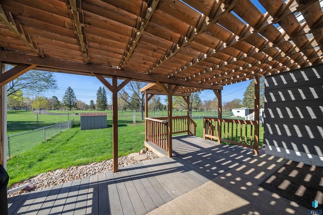 wooden deck with a lawn, an outbuilding, a fenced backyard, and a storage unit