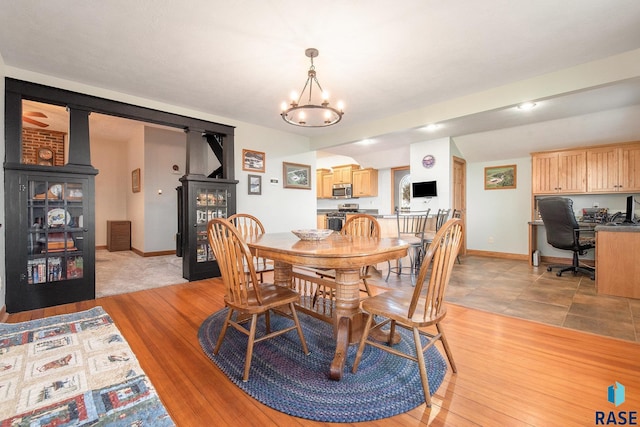 dining area featuring baseboards and a chandelier