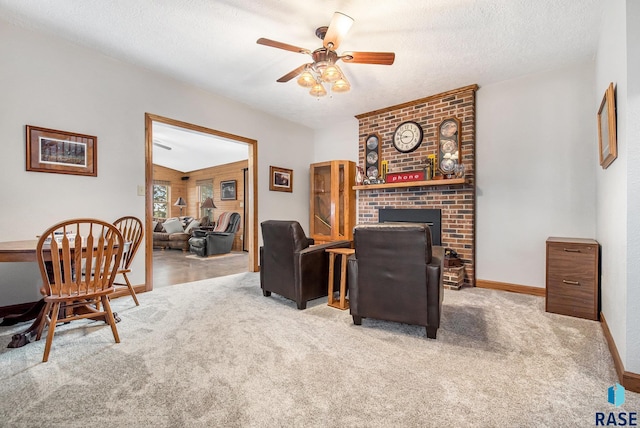 carpeted living room featuring a textured ceiling, baseboards, a ceiling fan, and a brick fireplace