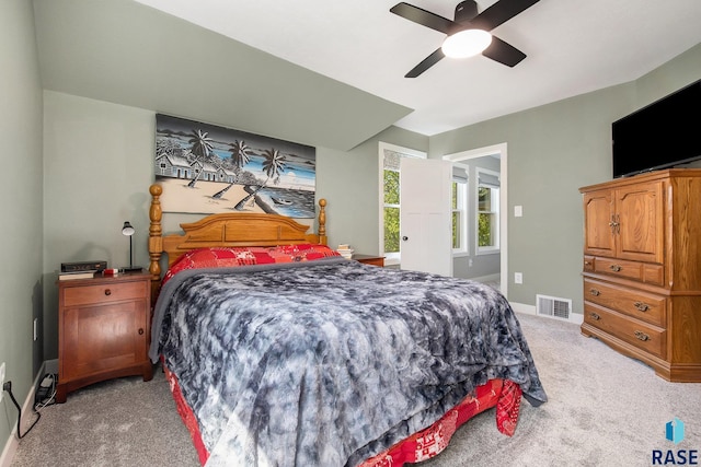 bedroom featuring light carpet, baseboards, a ceiling fan, and visible vents