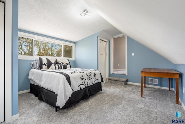 bedroom featuring lofted ceiling, baseboards, visible vents, and carpet