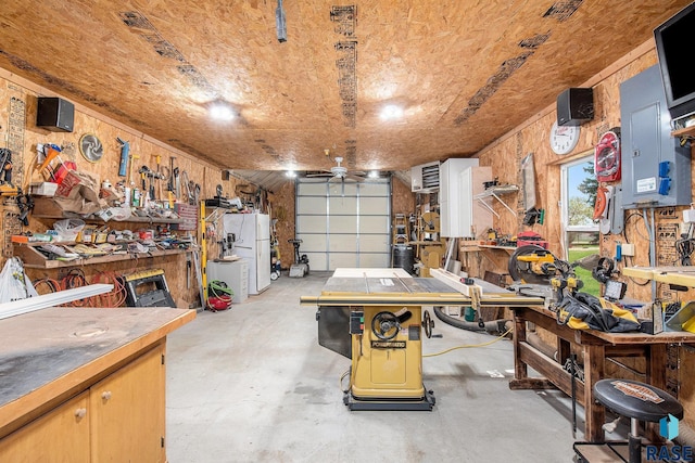 garage with a workshop area, wooden walls, and freestanding refrigerator