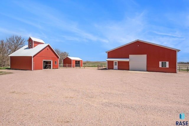 view of pole building with fence and a barn