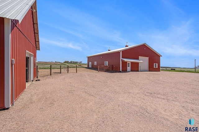 exterior space featuring a pole building, an outdoor structure, a garage, and fence