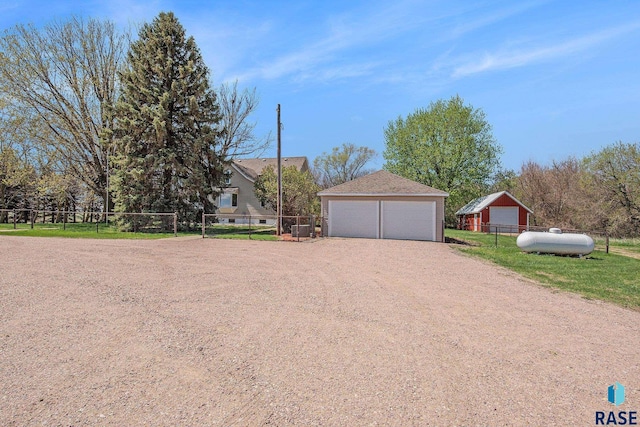 single story home with an outbuilding, fence, and a detached garage