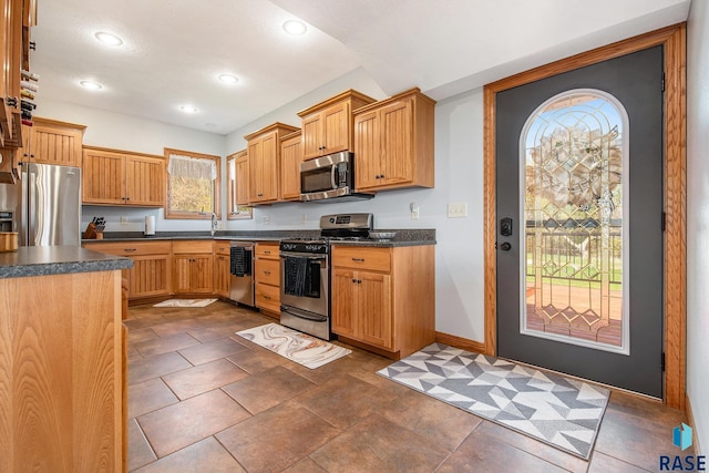 kitchen with baseboards, recessed lighting, dark countertops, and appliances with stainless steel finishes