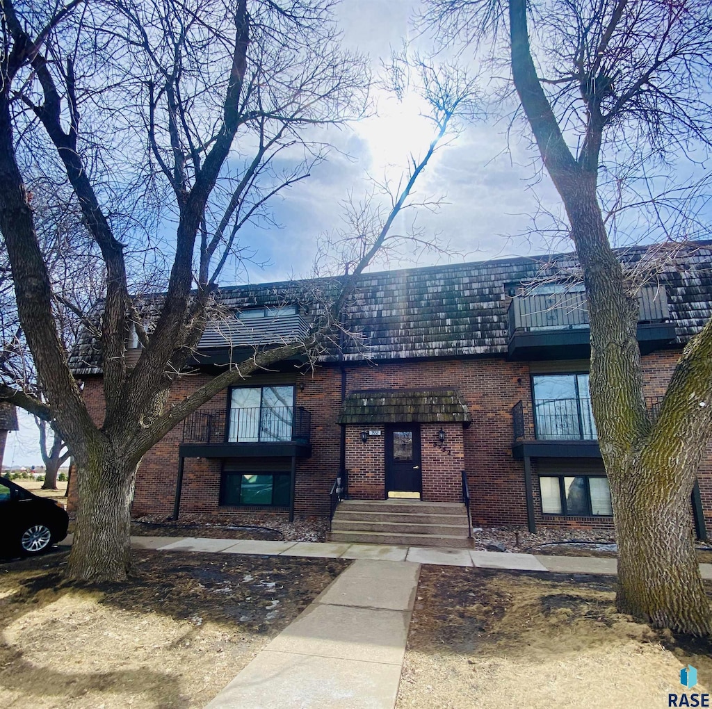 view of front facade with brick siding and mansard roof