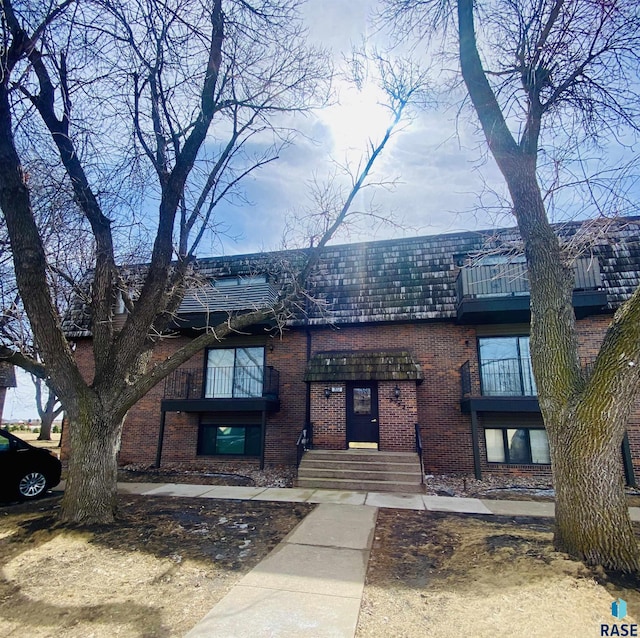 view of front facade with brick siding and mansard roof