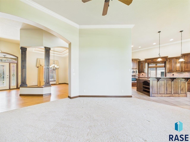 6204 S Doral Trl, Sioux Falls, SD 57108 - unfurnished living room with light carpet, ornamental molding, ceiling fan, baseboards, and arched walkways