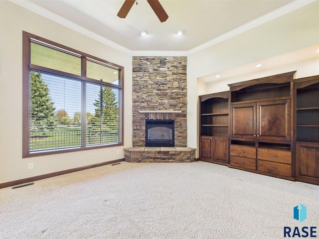 6204 S Doral Trl, Sioux Falls, SD 57108 - unfurnished living room featuring crown molding, carpet flooring, ceiling fan, a stone fireplace, and baseboards