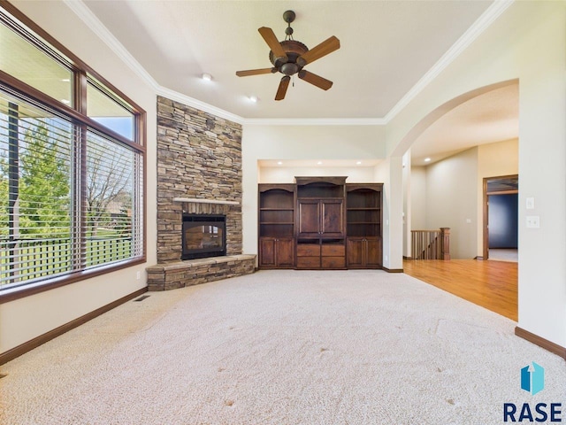 6204 S Doral Trl, Sioux Falls, SD 57108 - unfurnished living room featuring carpet flooring, arched walkways, a ceiling fan, crown molding, and baseboards