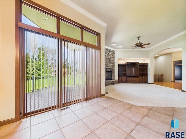 6204 S Doral Trl, Sioux Falls, SD 57108 - entryway featuring a stone fireplace, crown molding, a ceiling fan, arched walkways, and tile patterned flooring