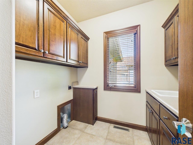 6204 S Doral Trl, Sioux Falls, SD 57108 - washroom with cabinet space, electric dryer hookup, baseboards, and light tile patterned floors