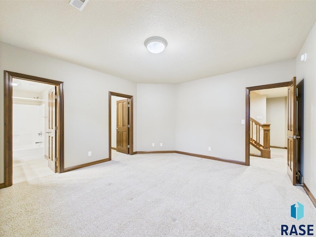 6204 S Doral Trl, Sioux Falls, SD 57108 - unfurnished bedroom with light colored carpet, a textured ceiling, baseboards, and ensuite bathroom