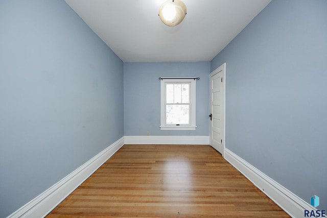 empty room featuring light wood finished floors and baseboards