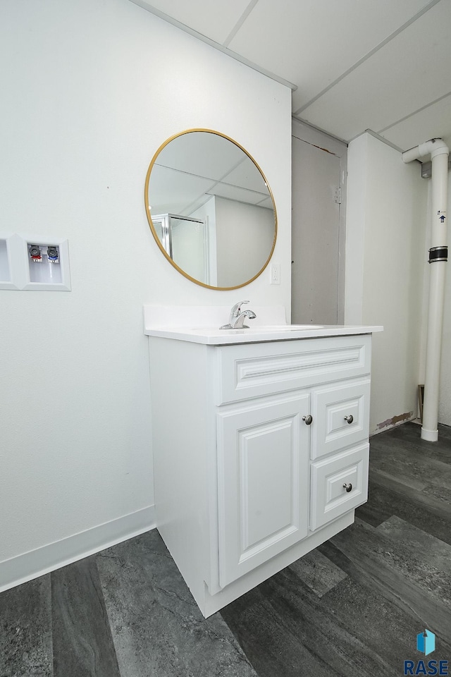bathroom with baseboards, wood finished floors, and vanity