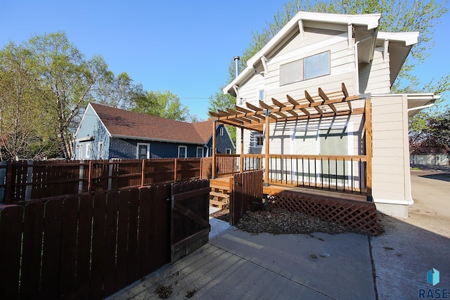 back of property featuring a pergola, fence, and a deck