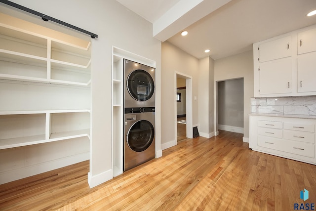 laundry room with stacked washer / dryer, laundry area, light wood-style flooring, and recessed lighting