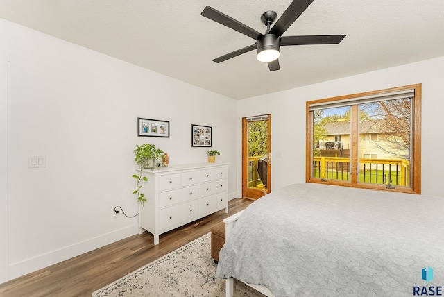 bedroom featuring a ceiling fan, access to outside, wood finished floors, and baseboards