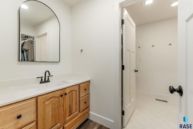 bathroom featuring baseboards, vanity, and visible vents